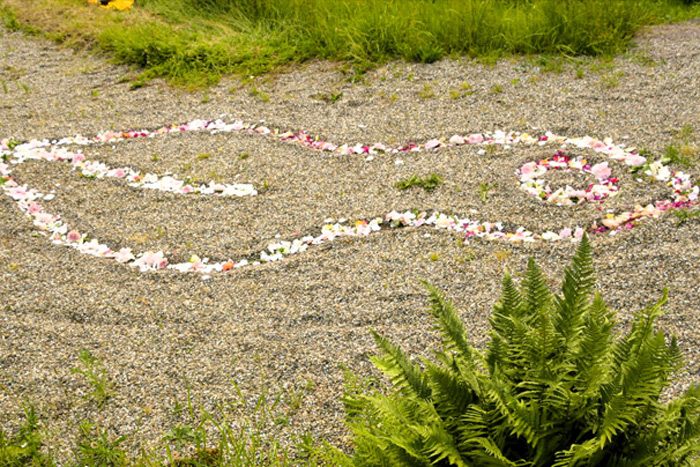 Logo des FrauenNetzwerk mit Blüten in Kies gelegt